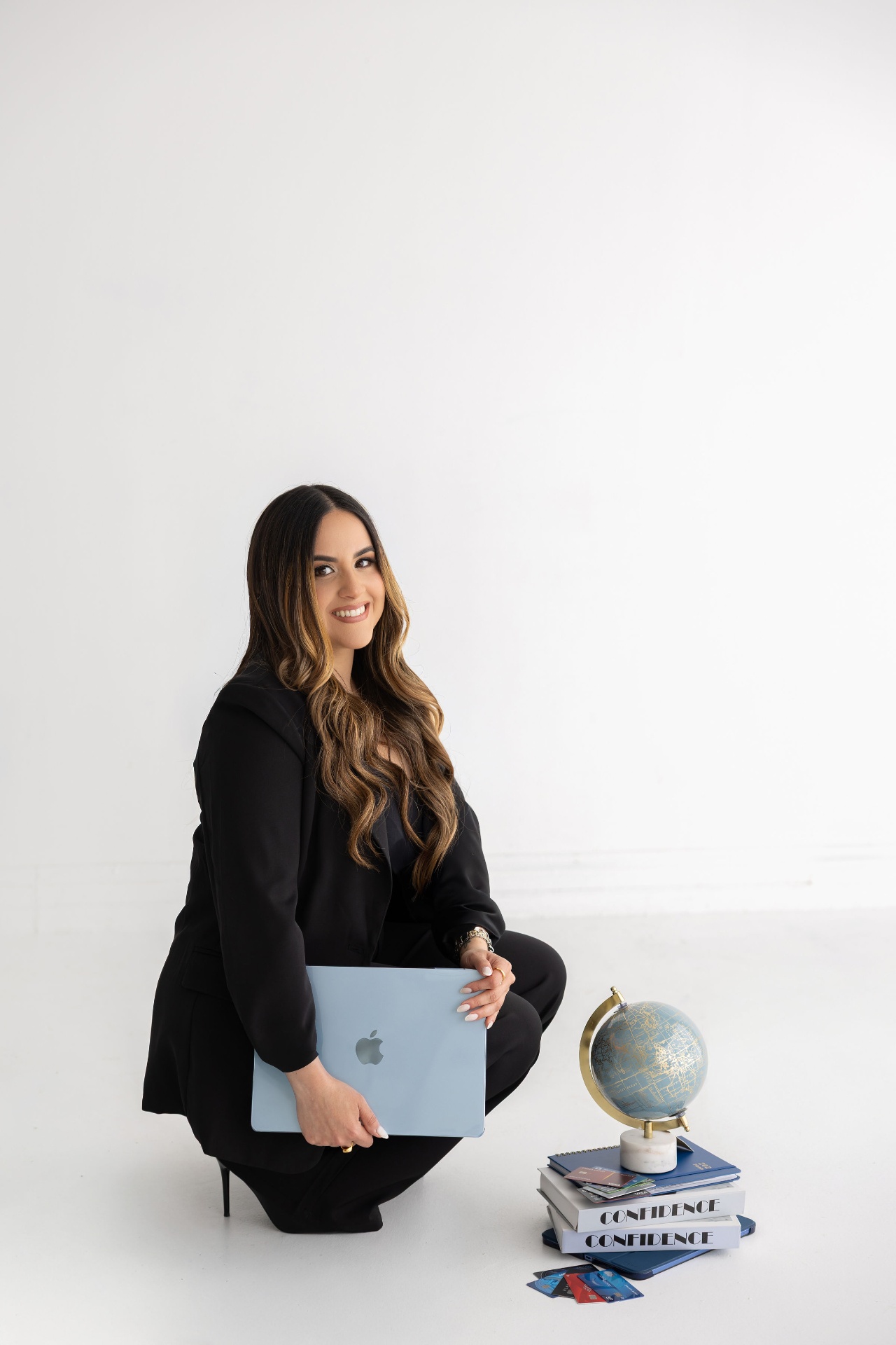 Mariangela Dominguez seated with a globe and books titled Confidence.